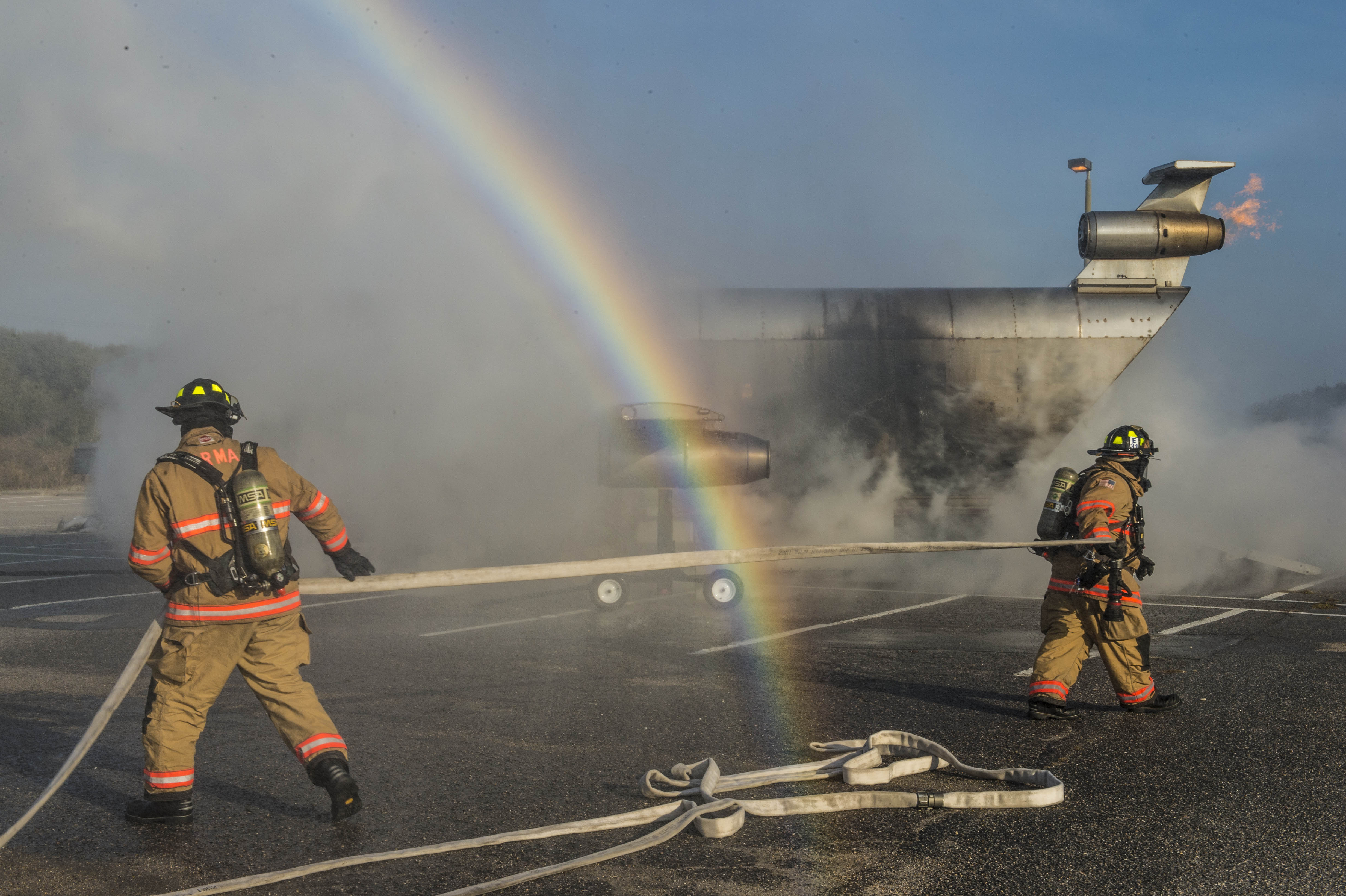 Firefighters advancing hose lines during a controlled training exercise
